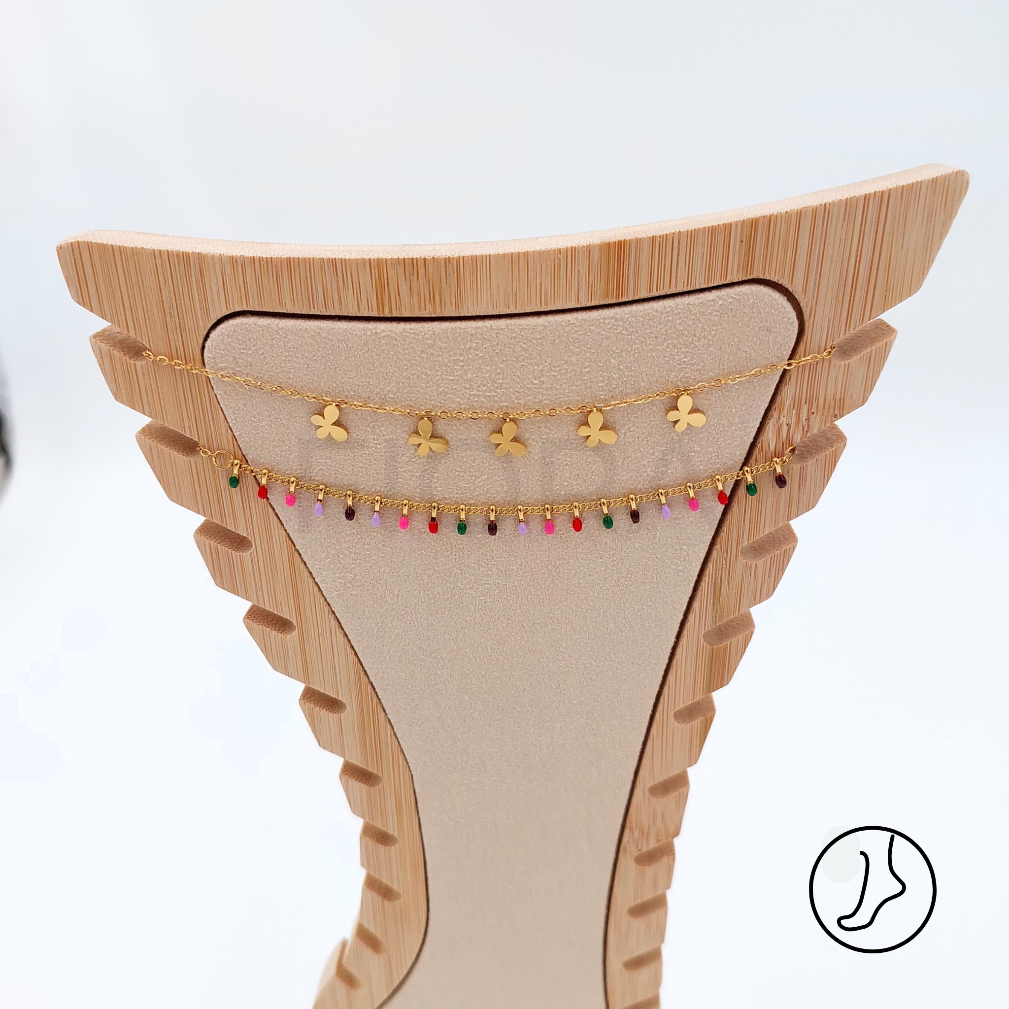 Double-chain anklet in gold with joyful floral charms and colorful beads.