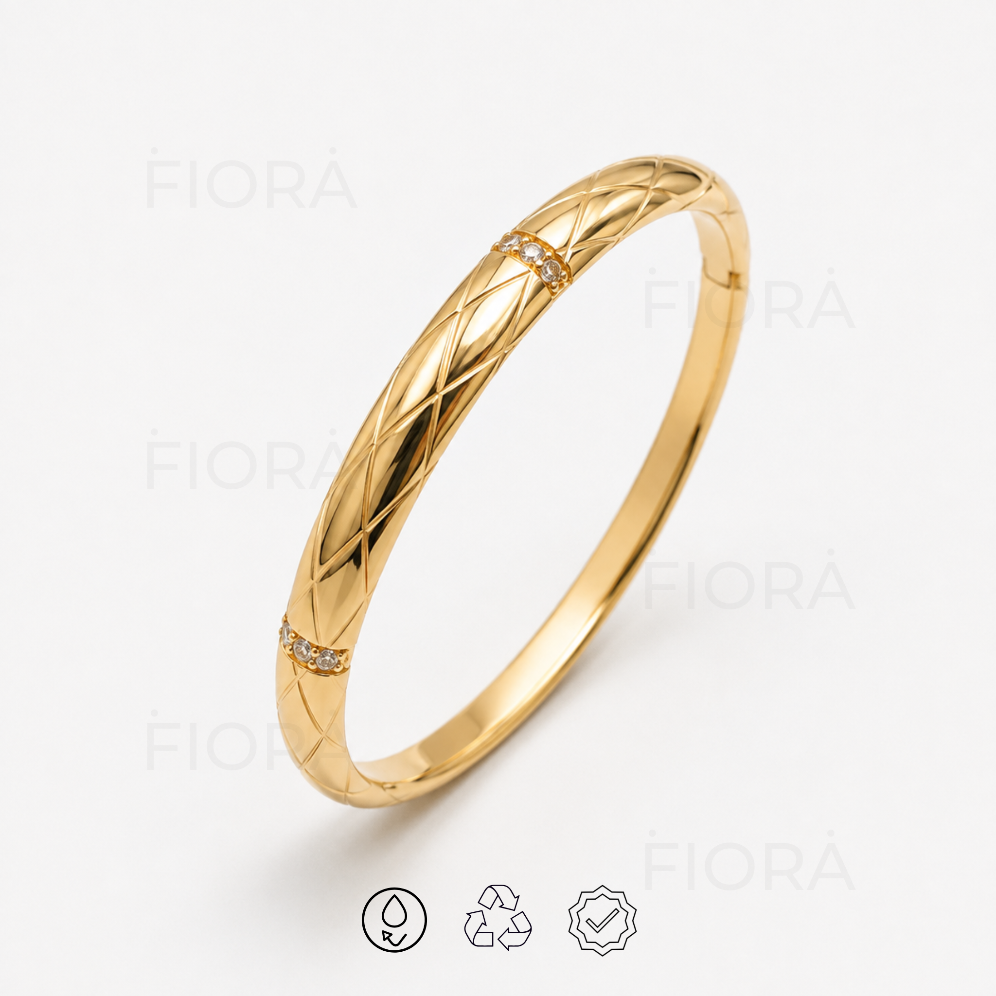 Angled view of Liora quilted gold bangle featuring polished engraved detailing and crystal accents.