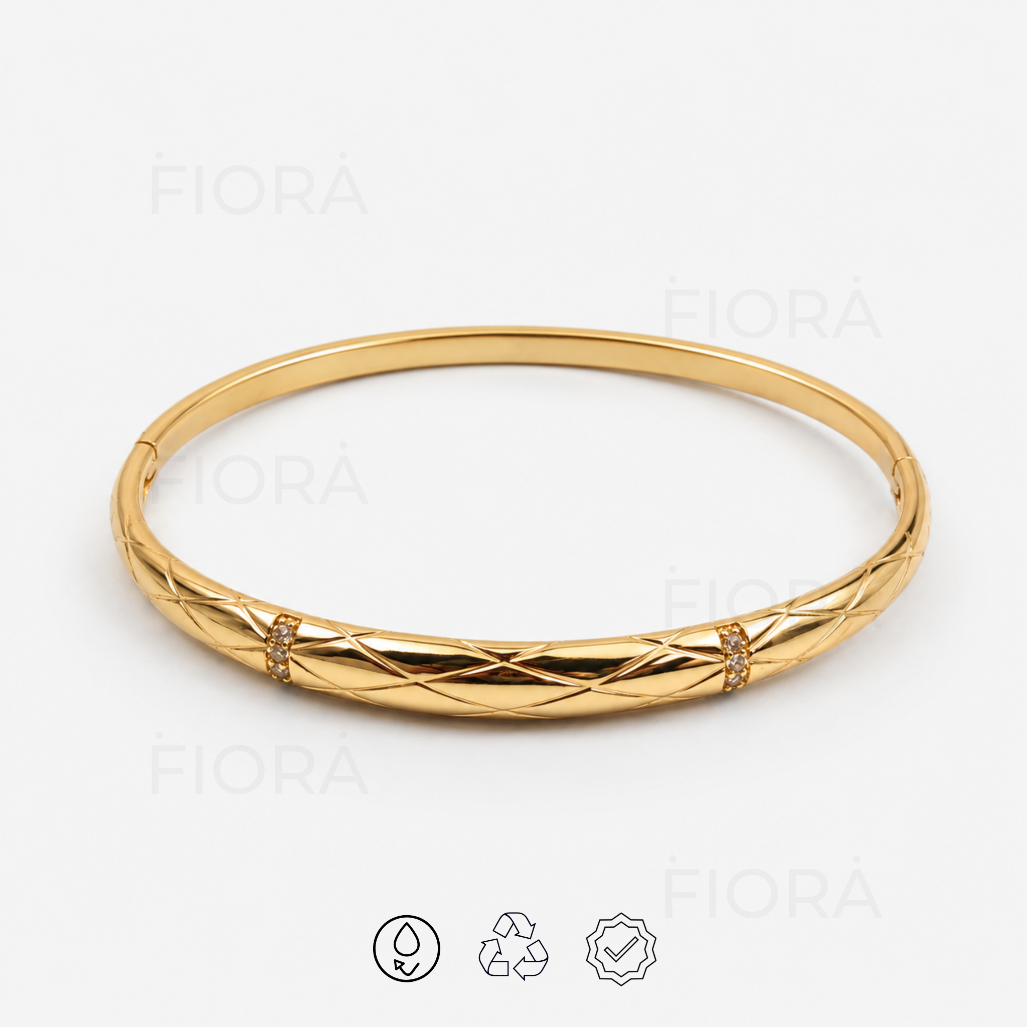 Front product view of polished gold quilted bangle with crystal details and hinged clasp.