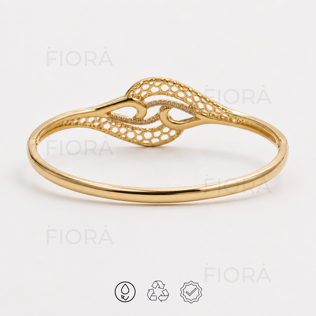 Rear elevated view of Serena Infinity gold-tone bangle showing circular band and intricate openwork centerpiece.