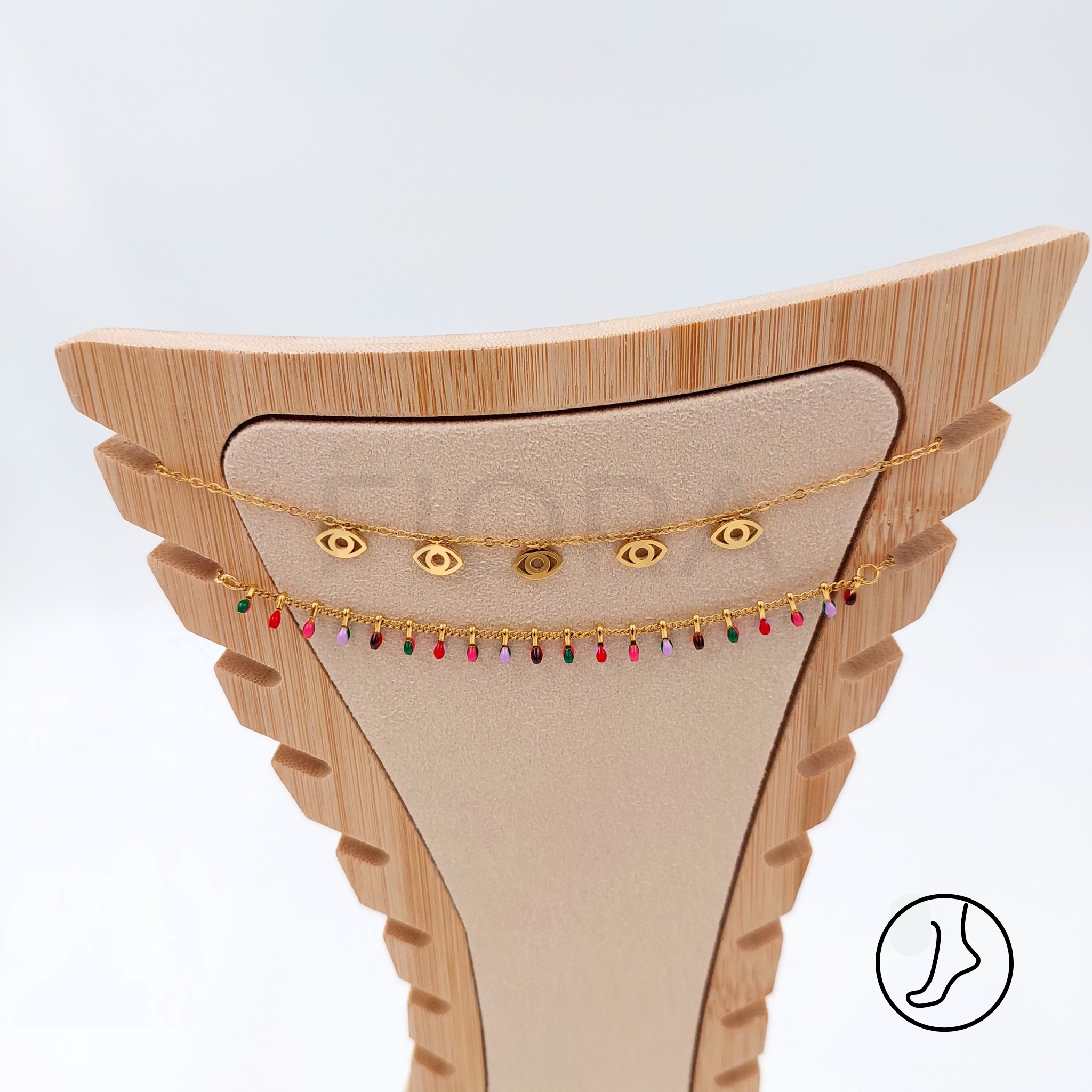 Double-chain gold anklet with eye charms and beads.