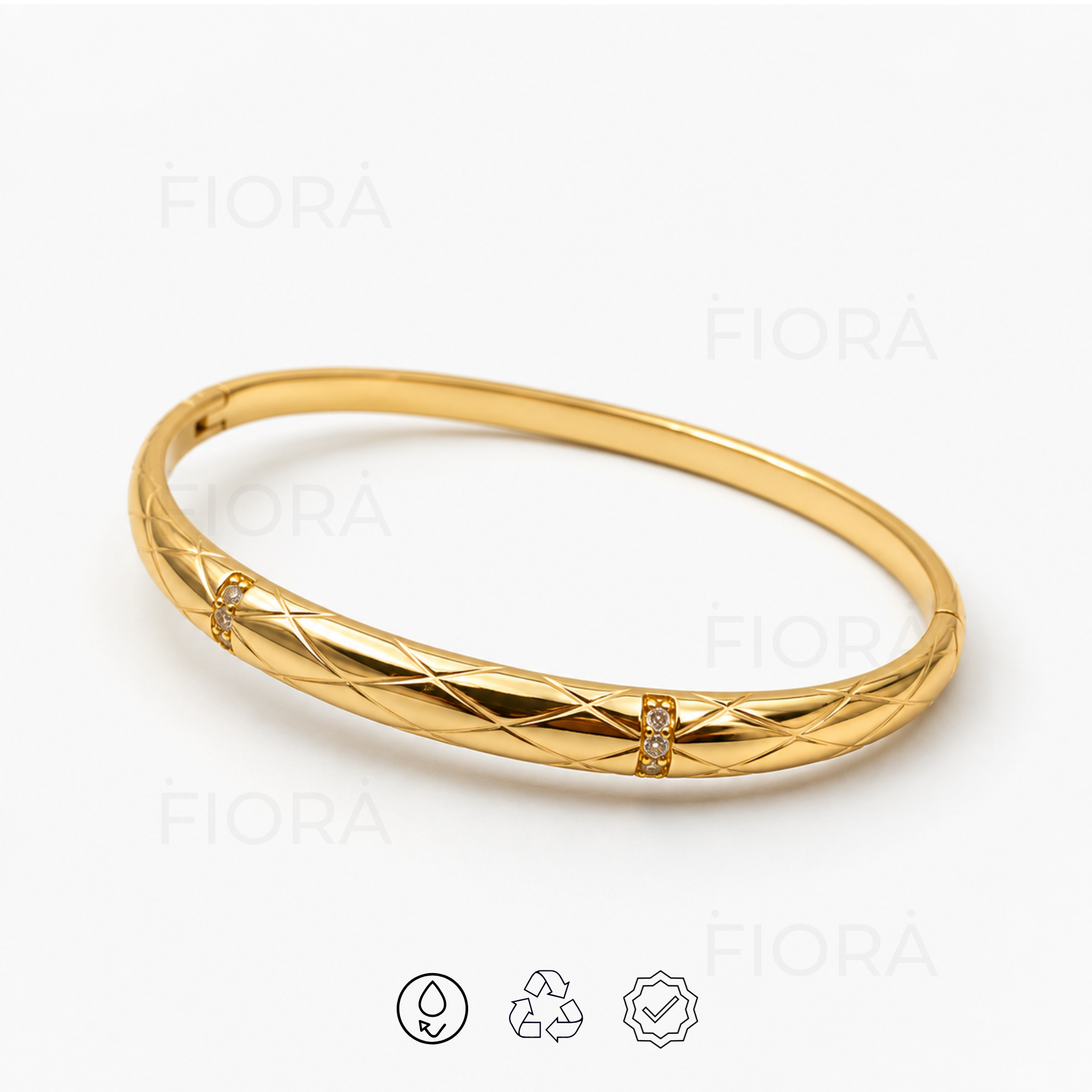 Angled view of Liora quilted gold bangle featuring polished engraved detailing and crystal accents.